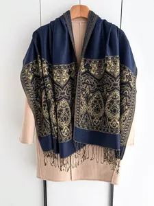 Detail of dark blue scarf with golden paisley patterns and elegant fringe tassels