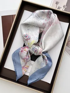 Detailed view of folded floral satin scarf with blue borders in a premium gift box