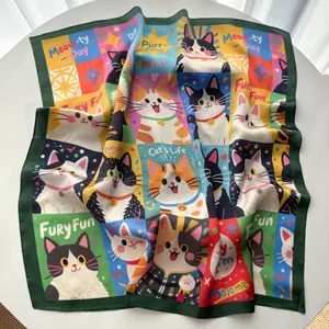 Détail d'un foulard carré en soie aux motifs de chats mignons sur une table blanche