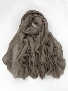 Detail of brown cotton linen scarf featuring natural crinkle texture and fringe edges