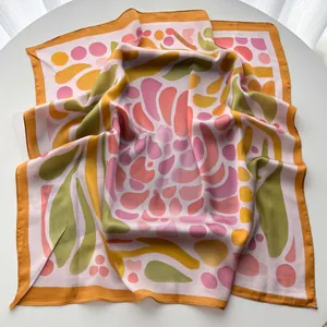 Detail of artistic floral silk scarf texture with rolled edges on a white surface