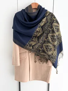 Detail of dark blue scarf with gold ethnic patterns and elegant fringe trim on wool coat