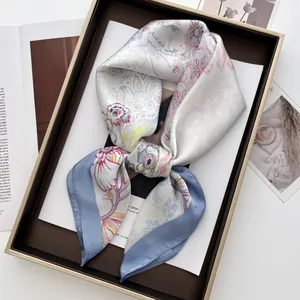 Close-up of silk square scarf with paisley floral print in an elegant gift box