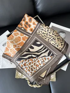 Detailed view of leopard and zebra print silk scarf with brown edges and care label