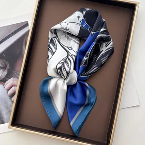 Nahaufnahme eines eleganten blau-schwarzen Seidenschals mit Satin-Finish in einer Box