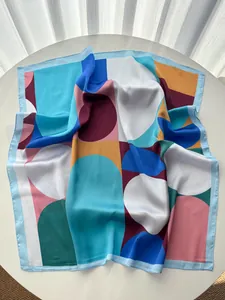 Detailed view of silky satin square scarf featuring colorful geometric polka dot patterns