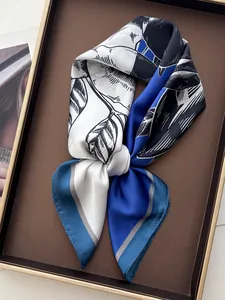 Detail eines blau-weißen Seidenschals mit Blumenmuster in einer Premium-Geschenkbox auf Magazin