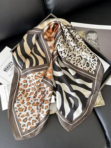Close-up of leopard and zebra print silk scarf textures on a premium leather sofa