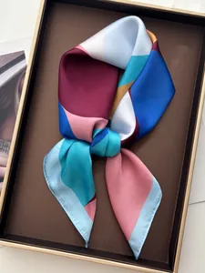 Detail of silk-like scarf with geometric patterns and elegant satin texture in a display tray