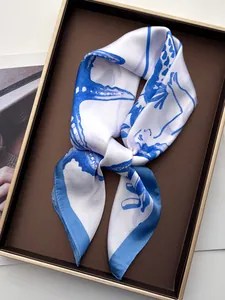 Detail of silk scarf with blue seahorse and starfish print neatly placed on a tray
