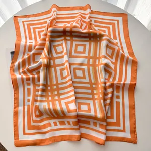 Dettaglio di un foulard di seta a righe arancio e bianco drappeggiato su base