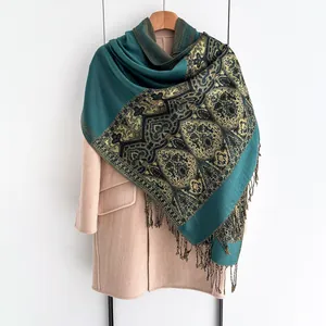 Close-up of retro ethnic scarf with peacock green weaving and golden fringe details