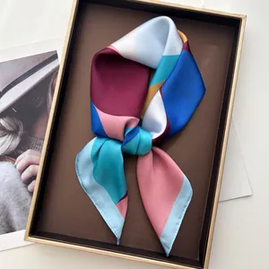 Macro detail of geometric patterned satin scarf folded in a luxury gift display box