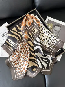 Detail of silk scarf with leopard and zebra patterns on a black leather background
