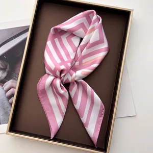Dettaglio di un foulard in raso setoso a righe rosa in una scatola regalo pregiata