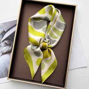 Detail of geometric pattern silk scarf presented in an elegant brown rectangle gift box