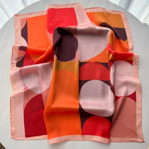 Close-up of silk square scarf featuring bold geometric dots and premium hemmed edges