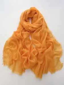 Detailed texture of orange cotton linen scarf with natural crinkle and fringe edges
