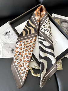 Detailed view of leopard and zebra print satin silk scarf with premium texture
