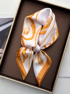 Detail of silk scarf with orange ocean starfish pattern inside a premium display box