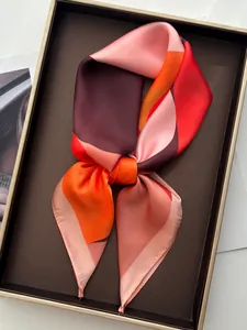 Detailed close-up of a geometric printed silk scarf tied in a knot on a display tray