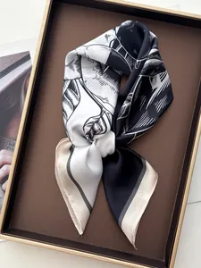 Detail eines Seidenquadrats mit handgemaltem Blattmuster auf einem eleganten Tablett