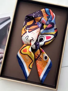 Détail d'un foulard soyeux avec des imprimés de chats abstraits sur un plateau