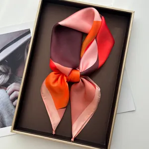 Detail of silk scarf with geometric warm tones in an elegant gift box presentation