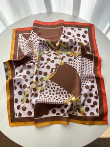 Detailaufnahme der Seidenschal-Textur mit Polka Dots und goldenem Kettenmuster
