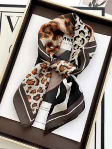 Detail of leopard print silk scarf elegantly tied in a gift box with a fashion background