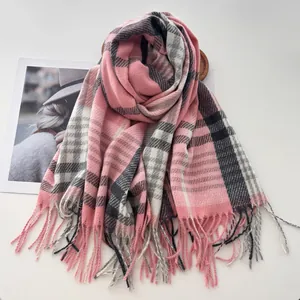 Détail d'une écharpe à carreaux rose avec franges douces et texture chaude