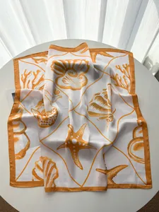 Detail shot of silk square scarf featuring orange starfish and seashell prints