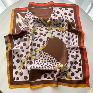 Nahaufnahme des braunen Seidentuchs mit Polka-Dots, Kettendruck und bunten Rändern
