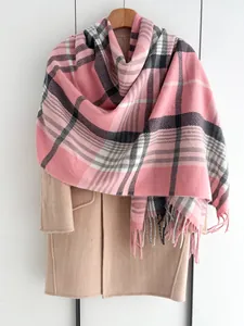 Gros plan d'une écharpe à carreaux bicolores avec de longues franges sur un manteau