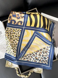 Detailed view of luxury silk scarf with animal print patchwork and rich yellow and navy tones