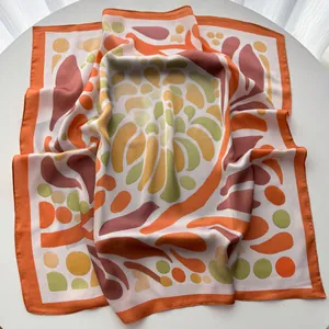Close-up of silk square scarf with geometric and botanical patterns in autumn colors