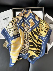 Detailed view of luxury animal print silk scarf featuring leopard patterns and blue borders