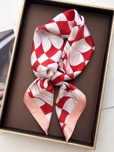 Detail showing wavy red and white geometric silk scarf folded in a premium gift box