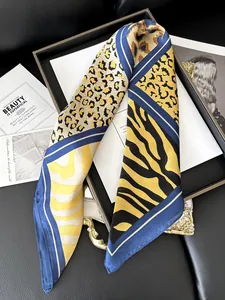 Detail view of a leopard and zebra print silk scarf draped over a black tray