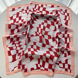 Detail of red and white twisted checkerboard pattern on smooth satin square silk scarf