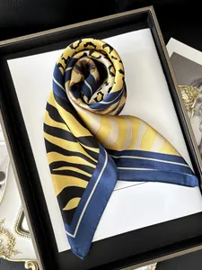 Detailed view of ginger and navy silk scarf featuring leopard and tiger prints