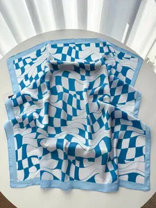 Close-up of blue and white distorted checkerboard silk scarf with rolled edges
