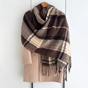 Vue détaillée d'une écharpe à carreaux marron et beige avec de douces finitions à franges