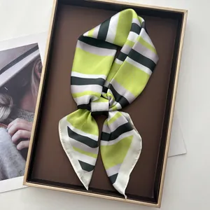 Detail of silk-satin scarf with green and grey stripes placed in a vintage display box