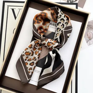 Elegant leopard print square silk scarf with geometric patterns in a luxury tray setting