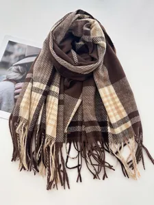 Gros plan sur la texture de l'écharpe à carreaux vintage avec franges marron et beige