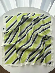 Detail of green and black striped silk scarf with elegant satin luster and rolled edges