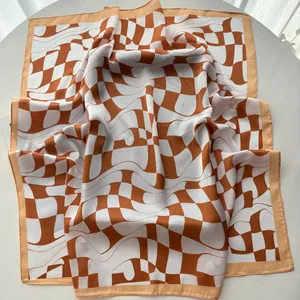 Detailed close-up of orange wave checkerboard silk scarf with smooth satin texture