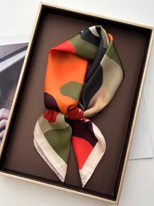 Detailed view of satin square scarf featuring vibrant geometric abstract patterns