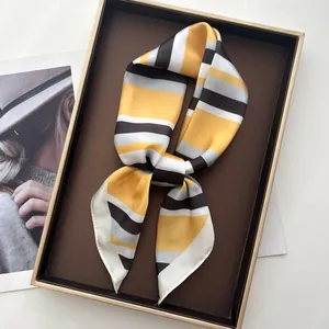 Detailed close-up of striped silk scarf texture and finish on a premium display tray